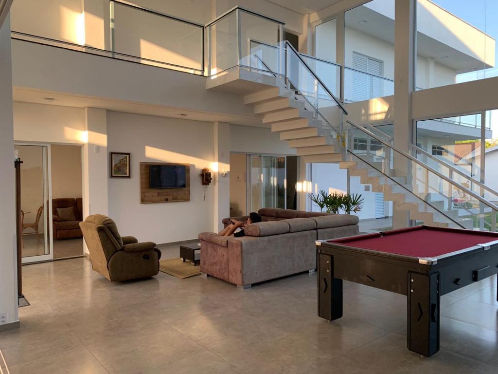 a living room with a pool table and stairs at Hospedaria Colinas in Indaiatuba