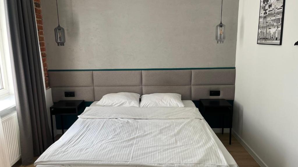 - un lit dans une chambre avec 2 oreillers dans l'établissement Kamienica Łódzka, à Łódź