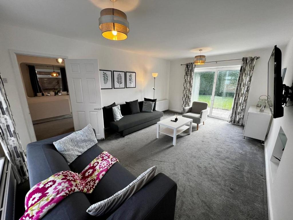 Spacious Family home in great location in Cardiff في كارديف: غرفة معيشة مع أريكة وطاولة