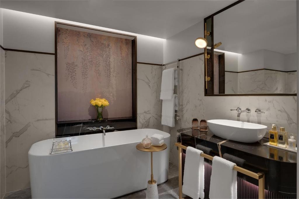 a bathroom with a large tub and a sink at The Biltmore Mayfair in London
