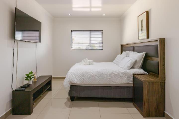 - une chambre avec un grand lit et une télévision dans l'établissement One bedroom apartment., au Cap