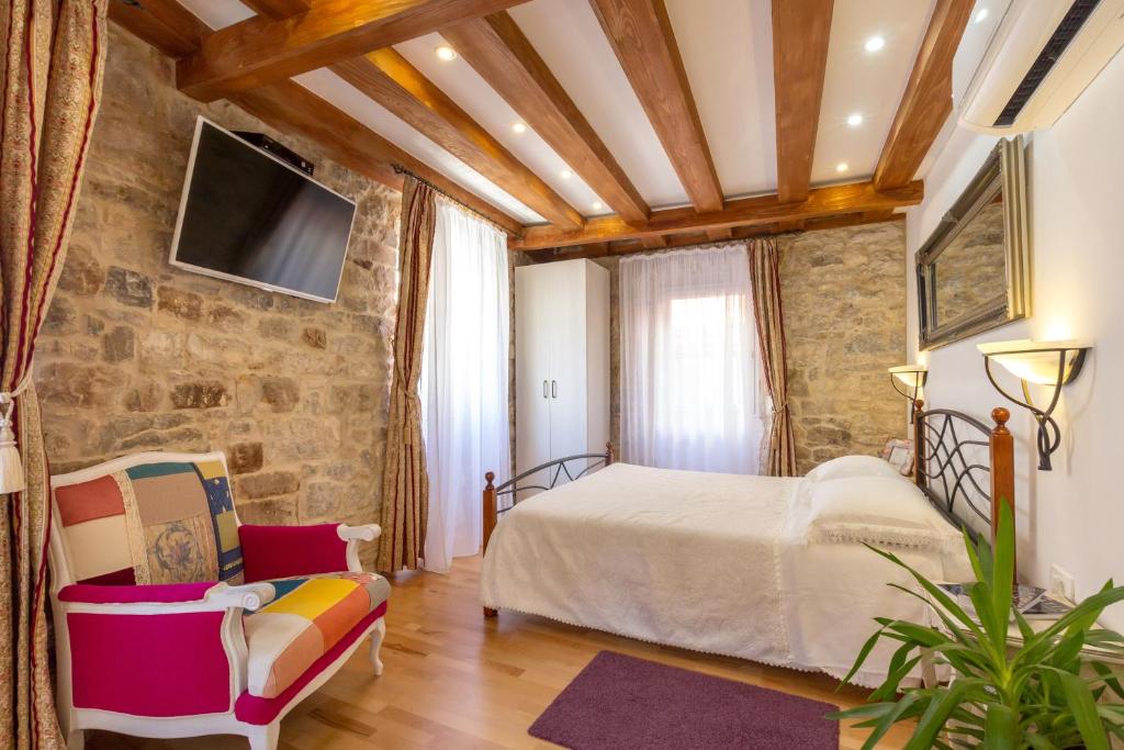 a bedroom with a bed and a stone wall at Studios Aurelia Palace in Split