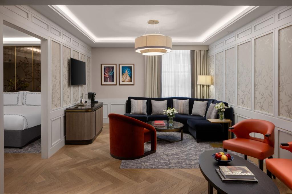 a living room with a couch and a bed at The Biltmore Mayfair in London