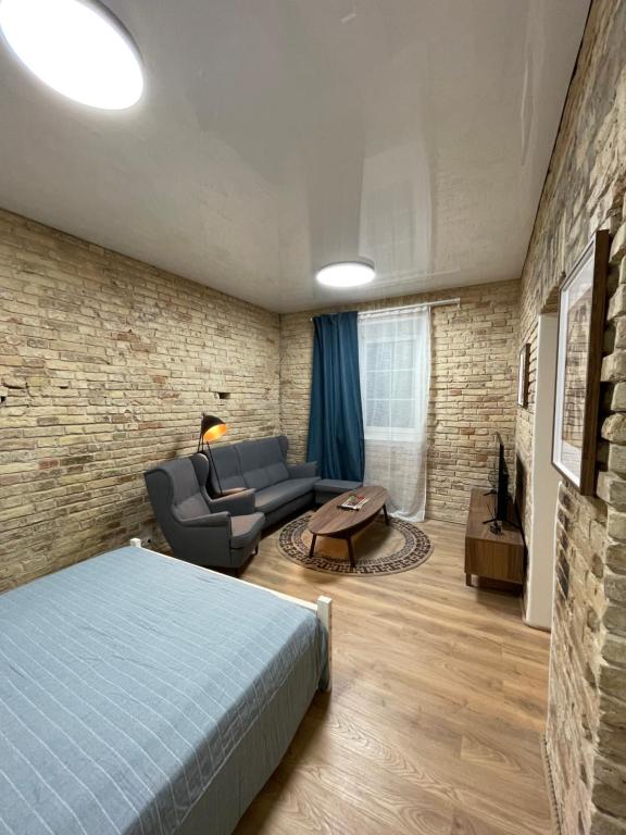 ein Schlafzimmer mit einem Bett, einem Sofa und einem Tisch in der Unterkunft Authentic Old Town Spot in Vilnius