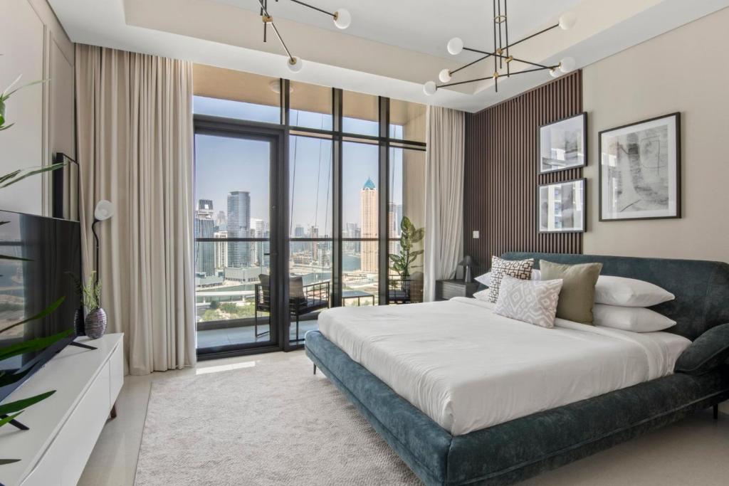 - une chambre avec un grand lit et une grande fenêtre dans l'établissement GuestReady - Contemporary studio in Business Bay, à Dubaï