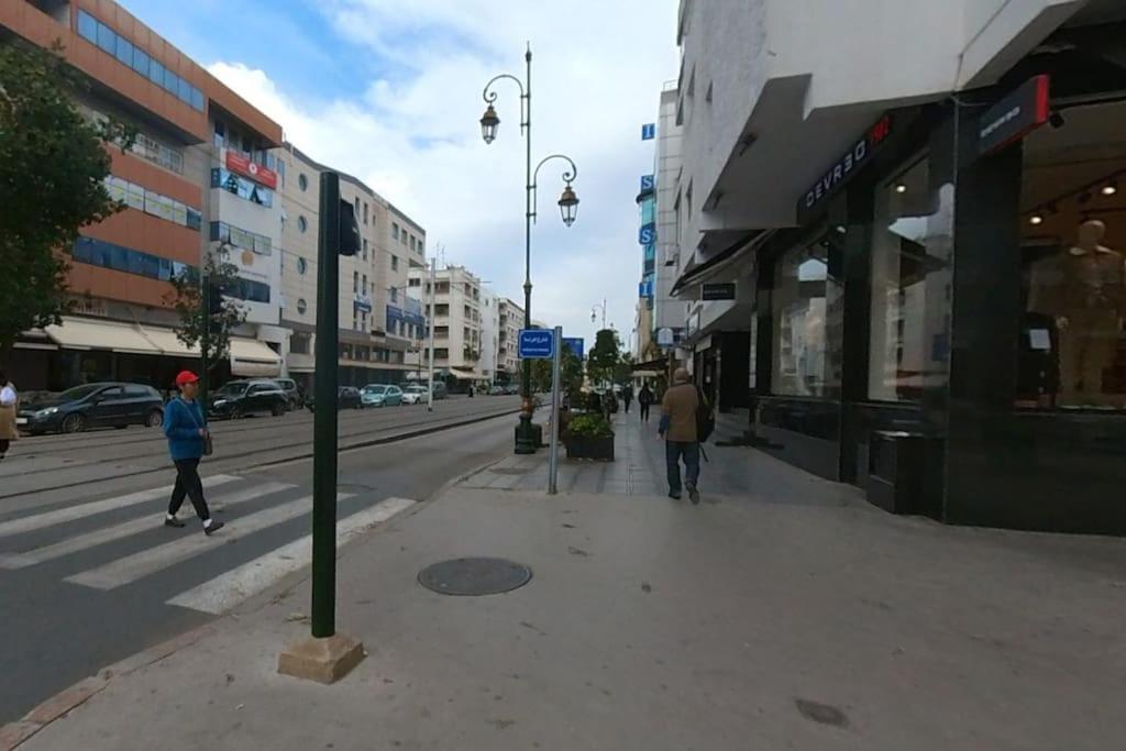 dos personas caminando por una calle en una ciudad en Studio Cosy moderne et climatisé, en Rabat