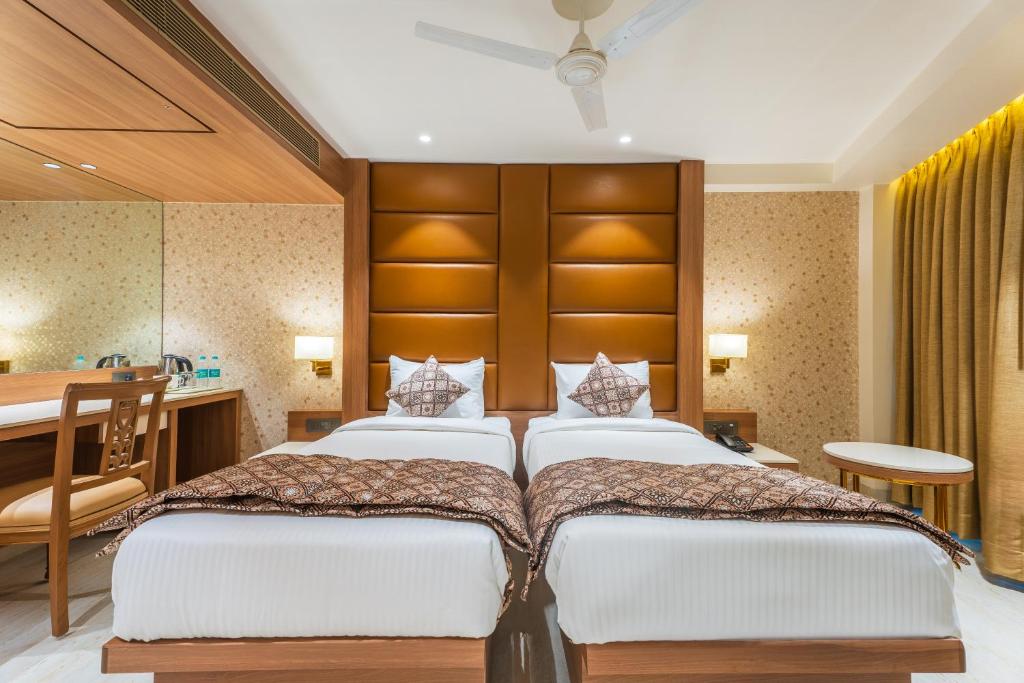 Habitación de hotel con 2 camas y escritorio en Hotel Supreme Comforts - International Airport, en Bombay