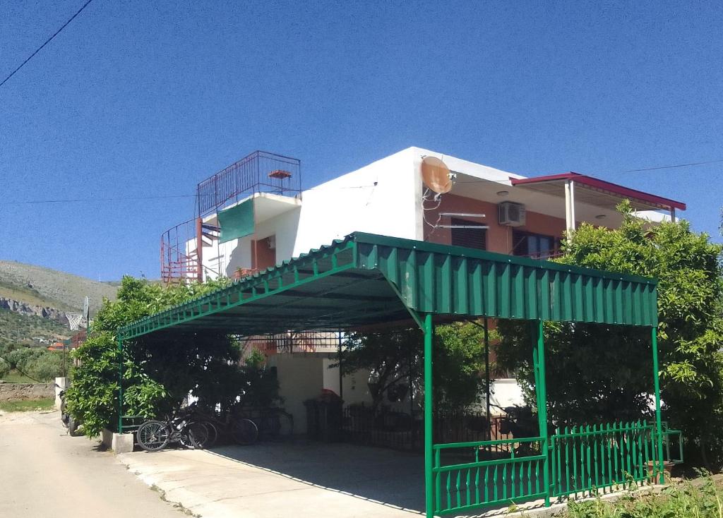 un edificio con una puerta verde delante de él en Apartment Luka, en Trogir