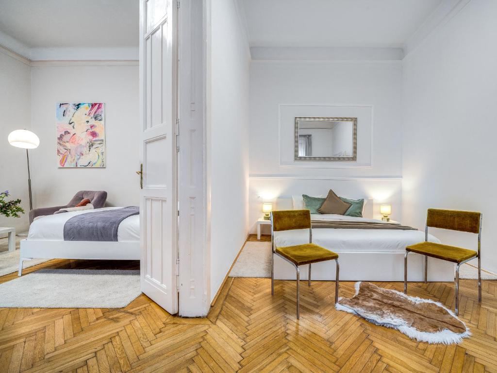 1 Schlafzimmer mit einem Bett und 2 Stühlen in der Unterkunft Székely Bertalan Residence in Budapest