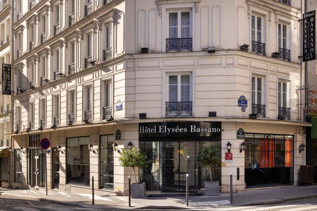 un bâtiment avec un magasin devant lui dans l'établissement Hotel Elysées Bassano, à Paris