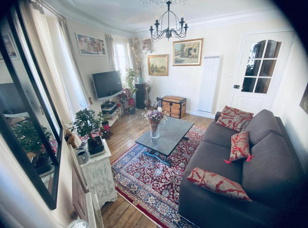 un salon avec un canapé et une table dans l'établissement Apartment Gugu Montmartre, à Paris