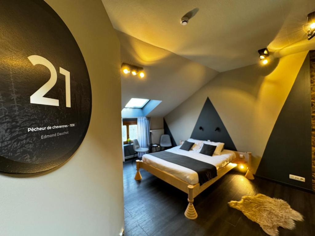 een slaapkamer met een bed en een bord aan de muur bij Hotel Val de Poix in Saint-Hubert