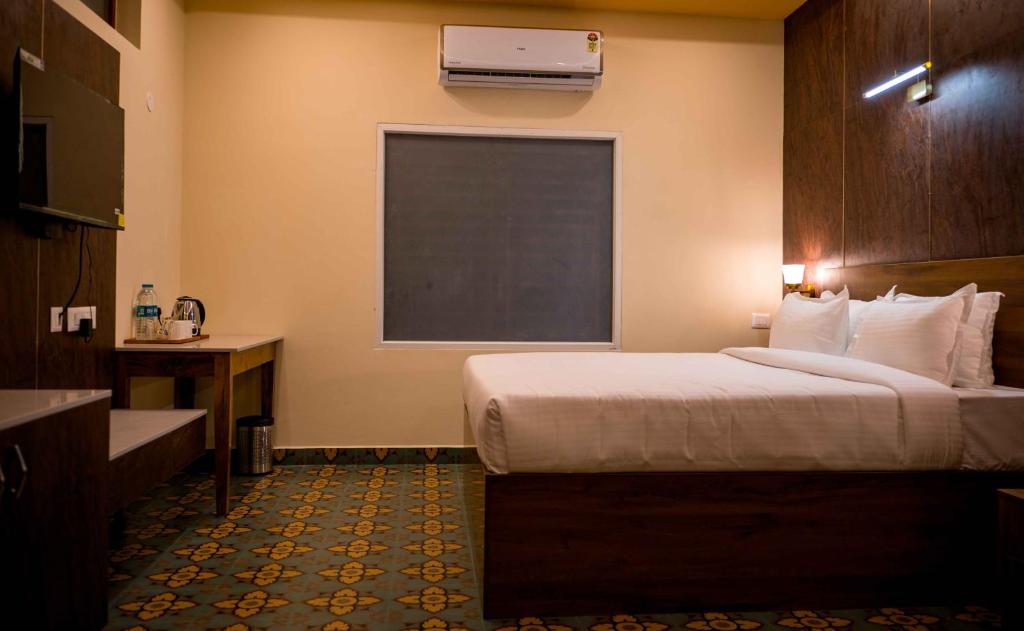 Postel nebo postele na pokoji v ubytování Poojaris Nirantara - Mysuru