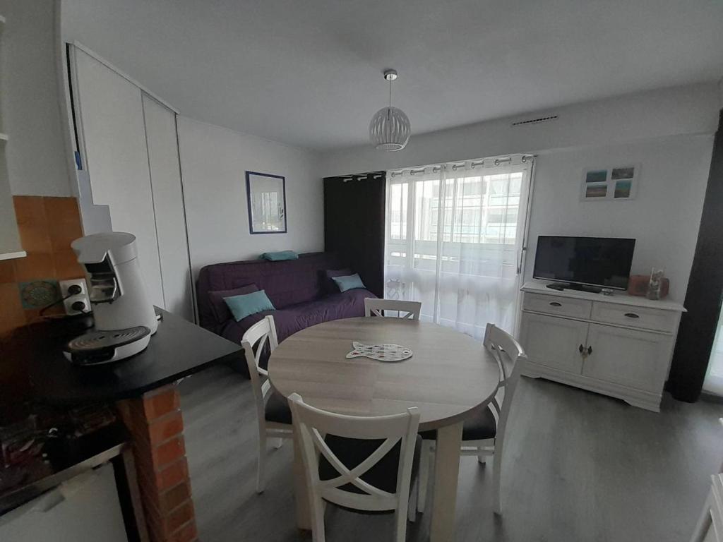 une cuisine et un salon avec une table et des chaises dans l'établissement Cosy studio rénové proche océan avec parking - FR-1-324A-58, à Saint-Hilaire-de-Riez