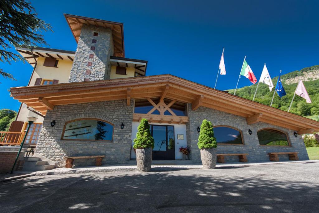 a building with flags in front of it at Sport Hotel Prodongo in Brallo di Pregola