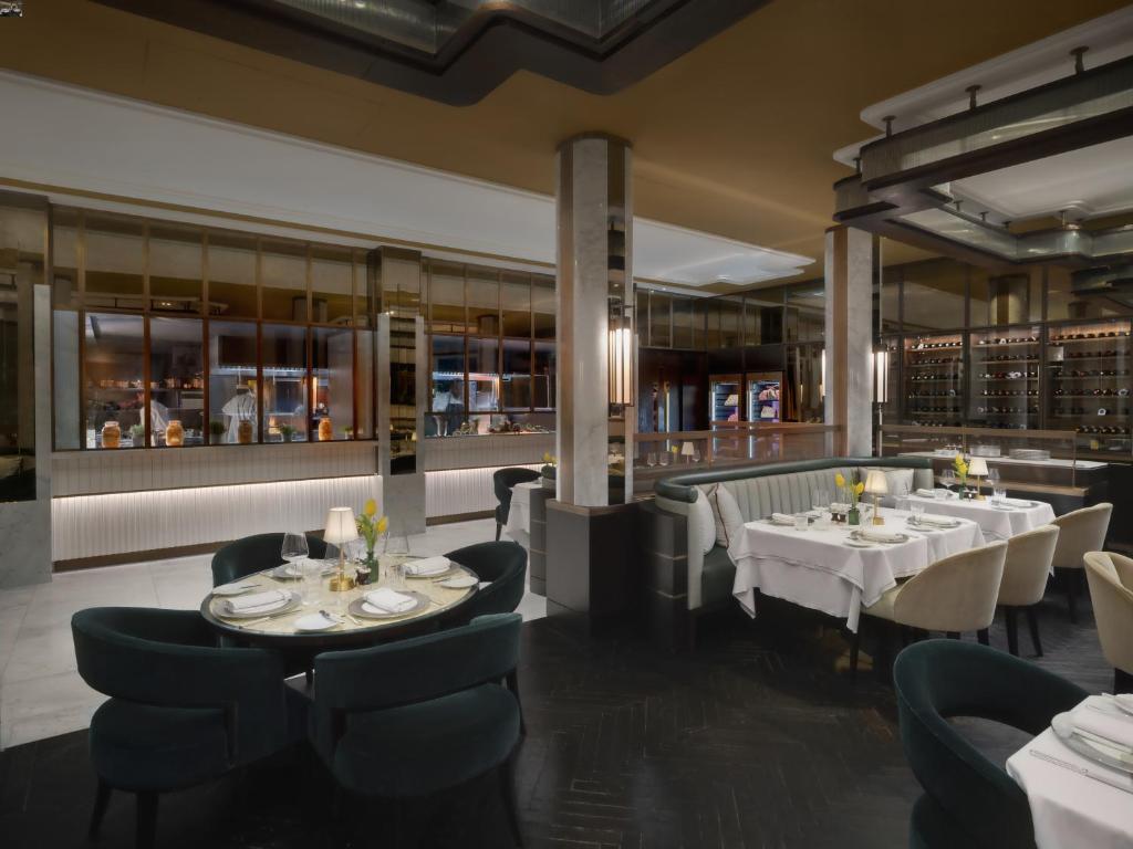 a restaurant with white tables and chairs and a bar at The Biltmore Mayfair in London