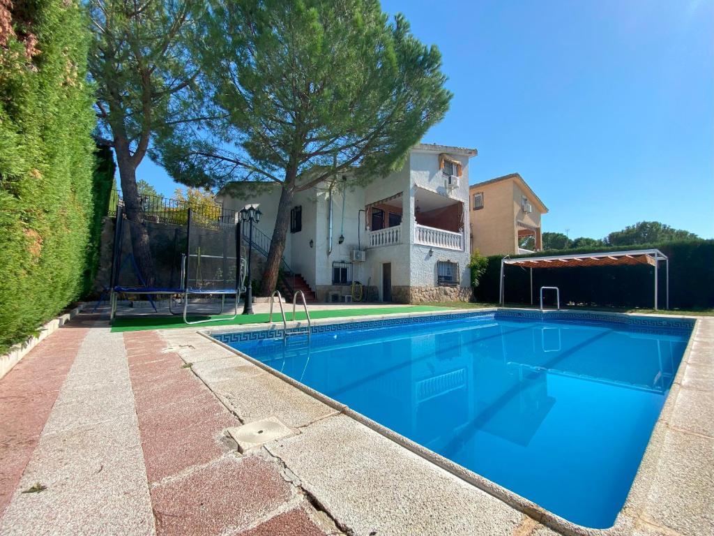 una piscina di fronte a una casa di Encantador chalet con piscina a Cardiel de los Montes