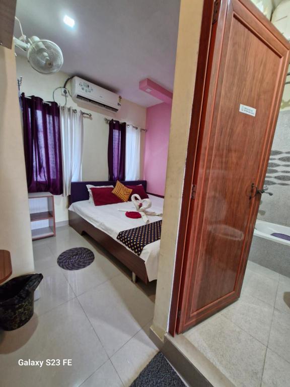 a bedroom with a bed and a wooden door at FAITH in Siliguri