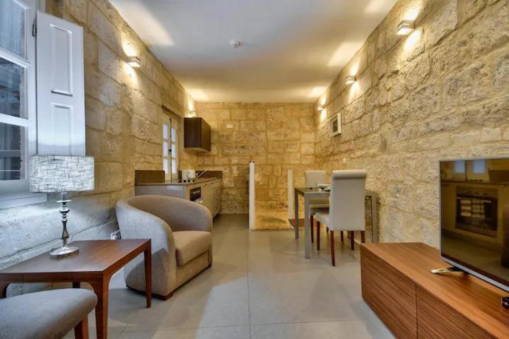 a living room with a couch and a table at Cosy 1BR home in the heart of vibrant Valletta by 360 Estates in Valletta