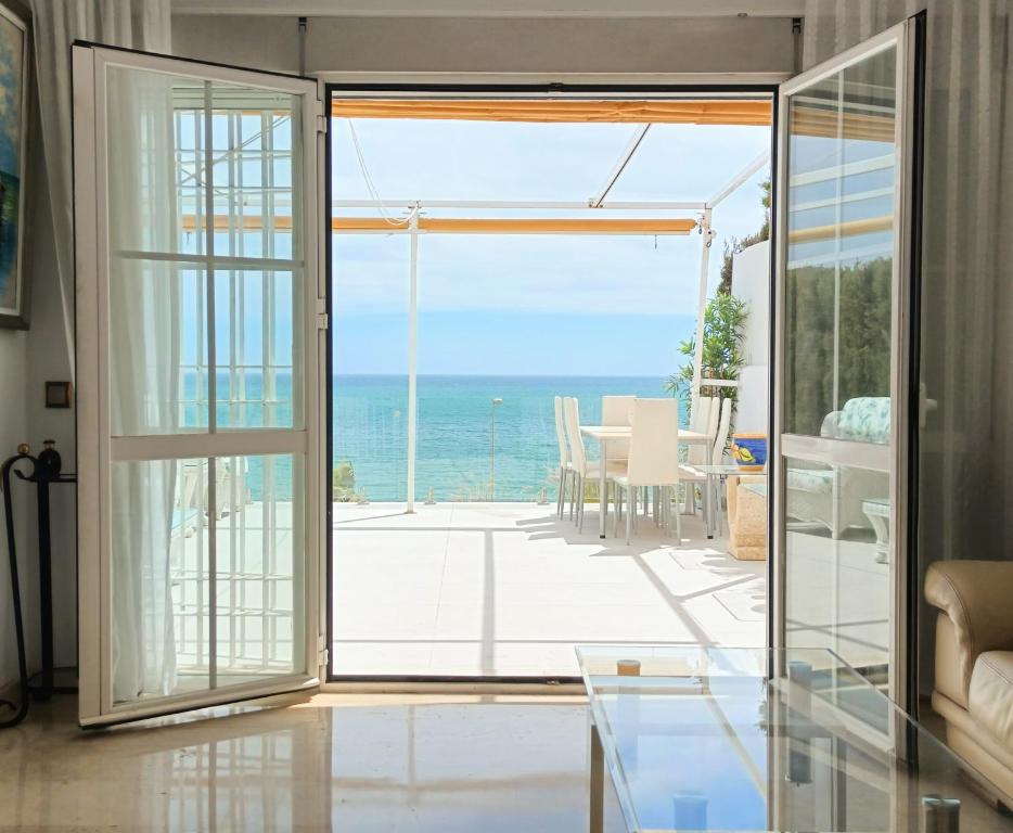 una puerta abierta a un patio con vistas al océano en Townhouse beachfront Benalmadena-Costa, en Benalmádena