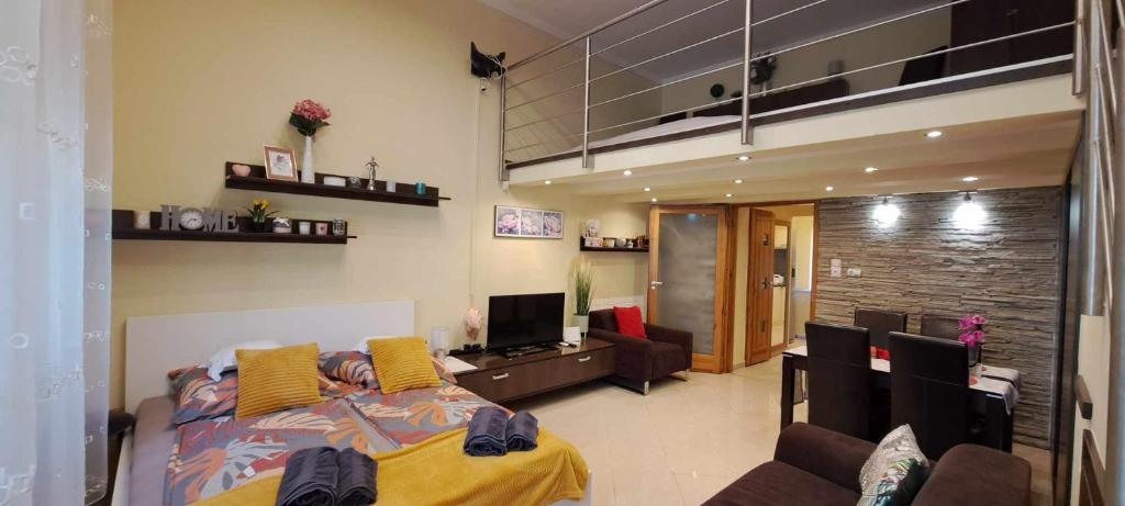 セゲドにあるSzandi Belvárosi Apartmanのベッドルーム1室(ベッド1台付)、リビングルームが備わります。