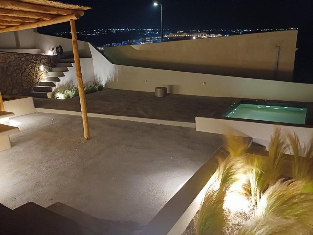 una casa con piscina por la noche en Santorini C Villa, en Fira