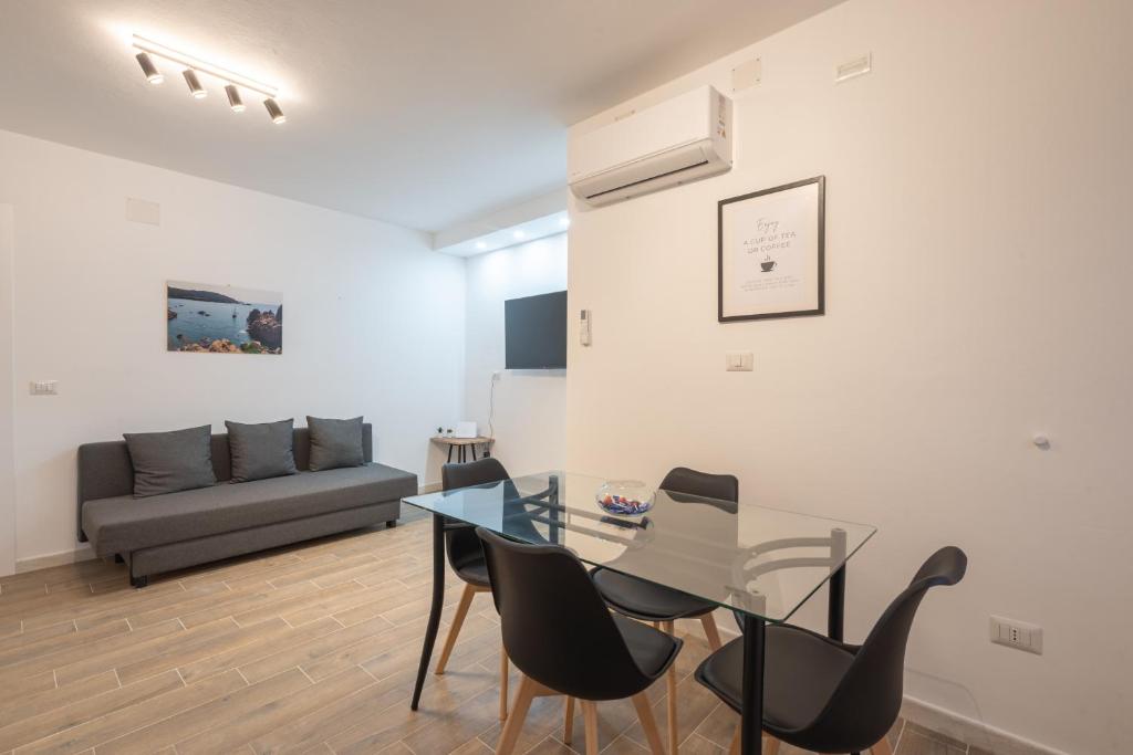 a living room with a glass table and chairs at Cavour Home in Porto Torres