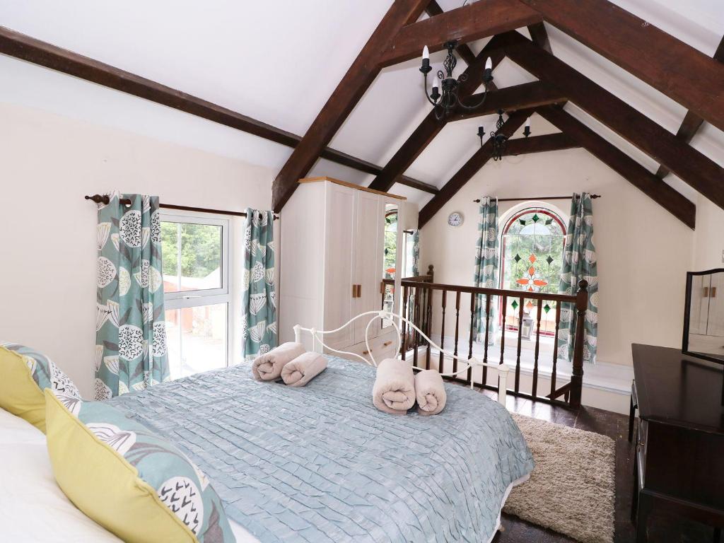 a bedroom with a bed with three stuffed animals on it at Ty Cloc in Llandysul