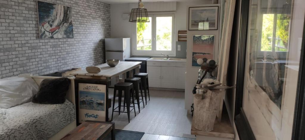Cette chambre comprend une cuisine avec une table et un lit. dans l'établissement Chalet vue sur mer, à Saint-Martin-Plage