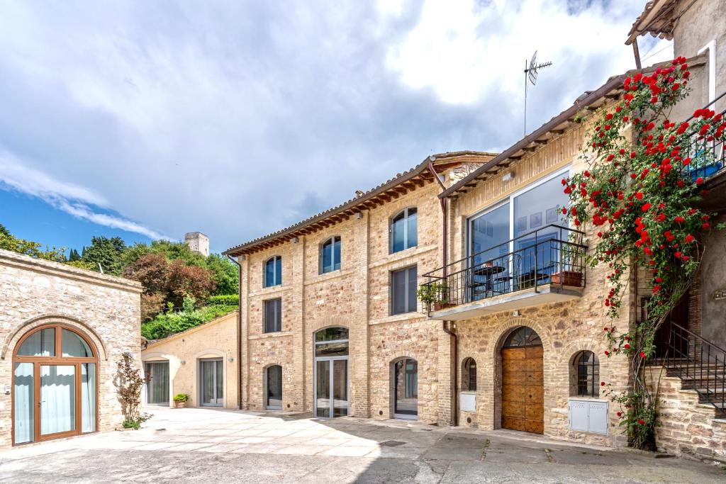 アッシジにあるAnfihouse - Assisi Relaisのガラスドアとバルコニー付きの古い石造りの家