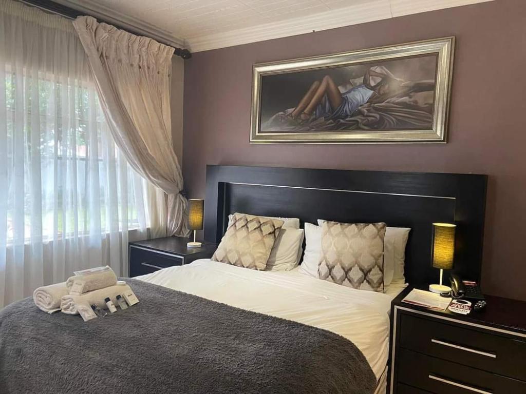 a bedroom with a bed with a stuffed animal on it at Whitehouse Lodge Benoni in Benoni