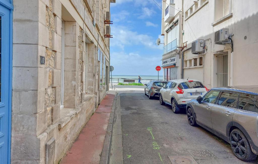deux voitures garées dans une rue à côté des bâtiments dans l'établissement 3 Bedroom Gorgeous Home In Royan, à Royan