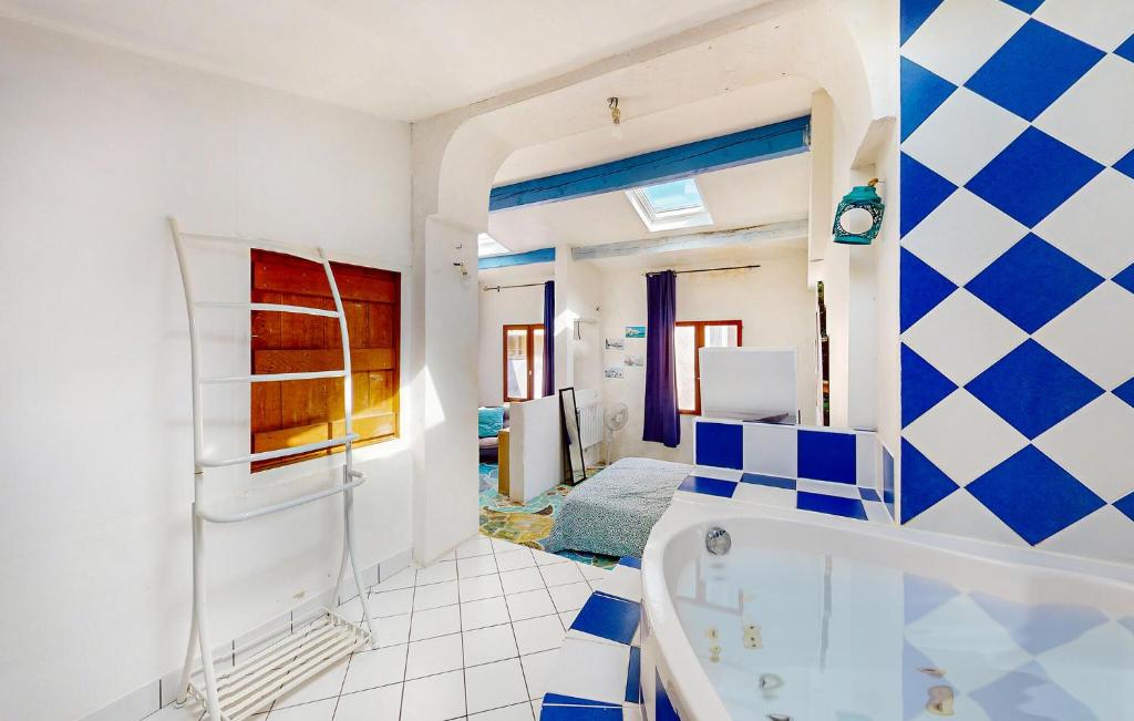 a blue and white bathroom with a tub at 4 Bedroom Cozy Home In Royan in Royan
