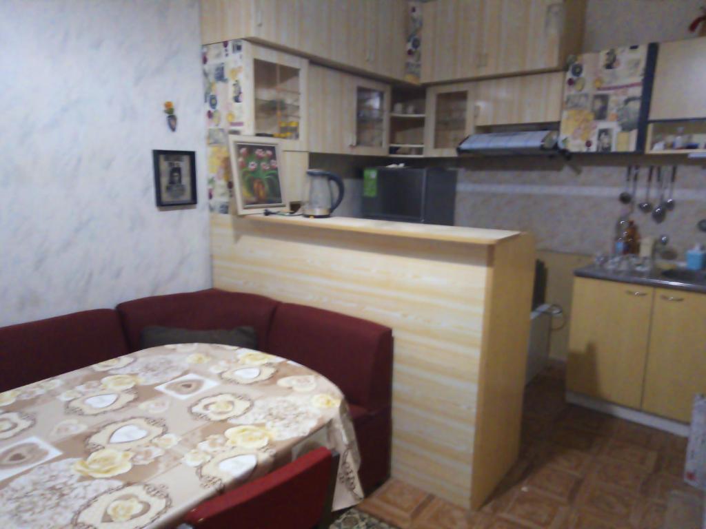 eine Küche mit einem Tisch, einem Tisch und einem Tisch sowie einer Küche in der Unterkunft Къща за гости ОАЗИС in Ruse