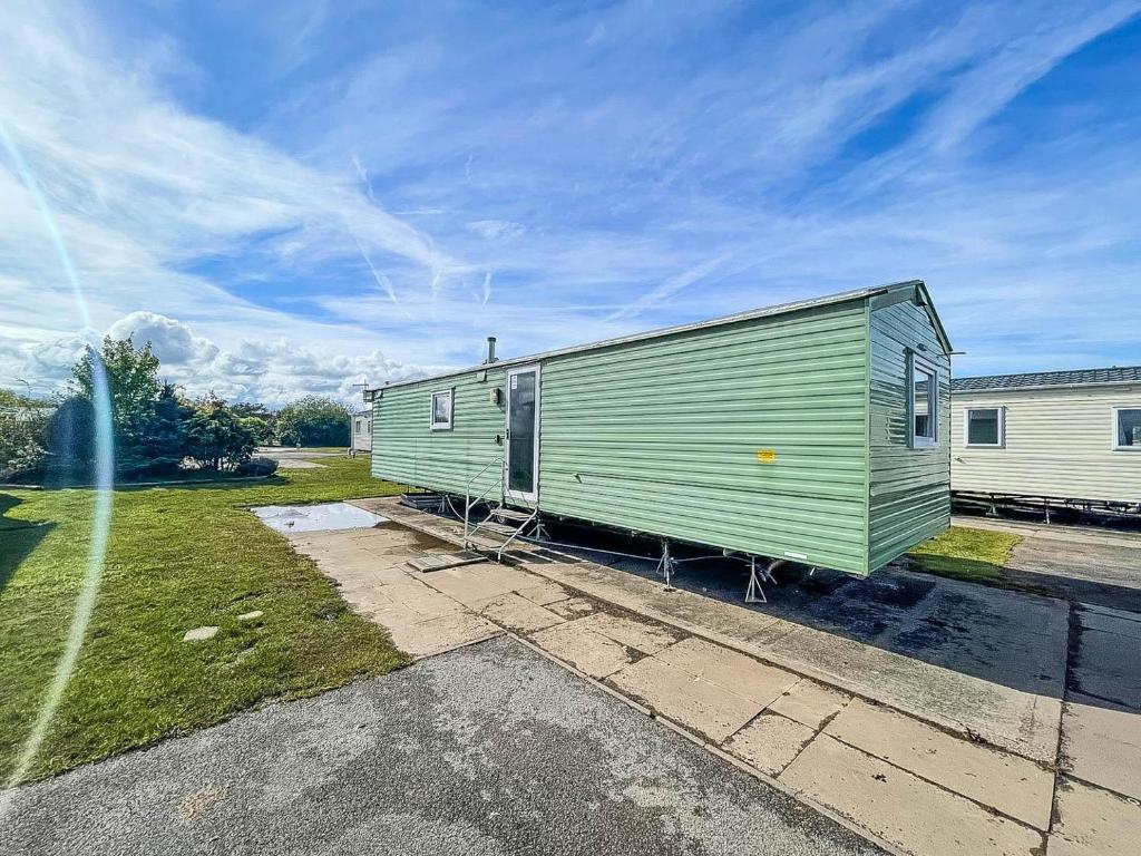 a green trailer parked next to a building at Lovely 8 Berth Caravan At Southview Park Nearby Skegness Ref 33009v in Skegness