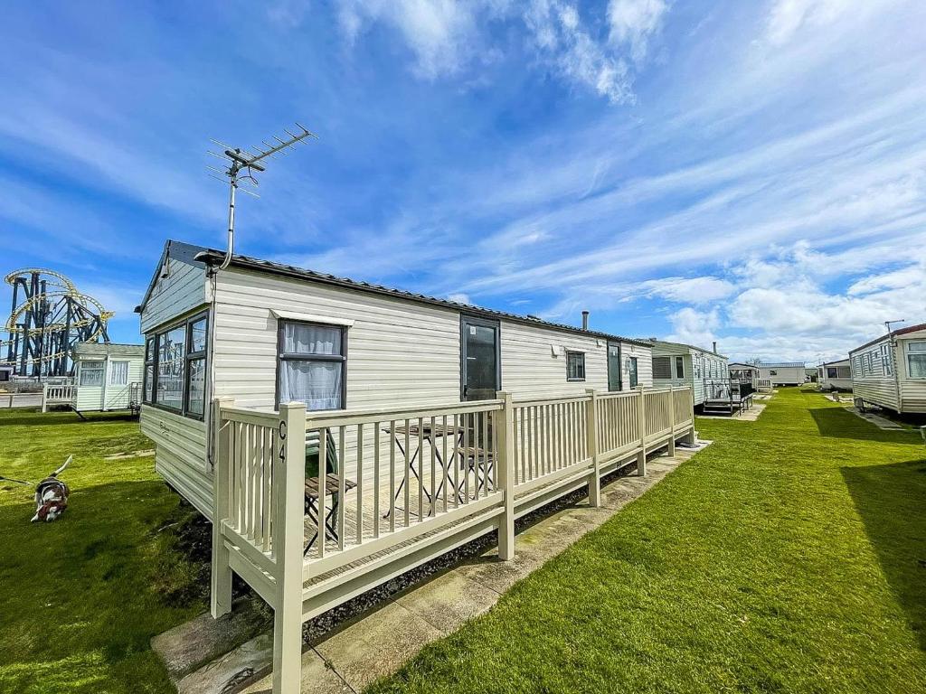 a mobile home with a deck and a roller coaster at Lovely 8 Berth Caravan With Decking At Eastgate Fantasy Island Park Ref 58004c in Skegness