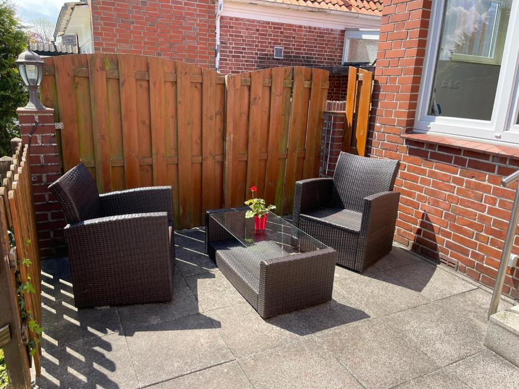 a patio with two chairs and a table and a fence at Lust auf Meer - Ferienappartement in Cuxhaven