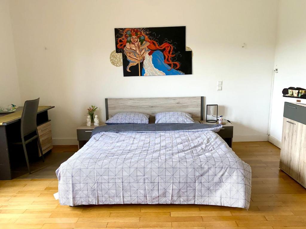 1 dormitorio con 1 cama y una pintura en la pared en Rue Des Glacis Limpertsberg, en Luxemburgo