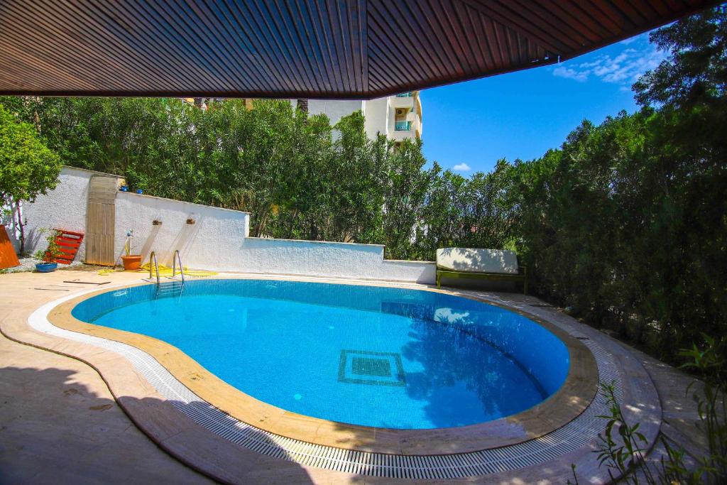 馬爾馬里斯的住宿－Villa Aslı Marmaris Günlük Haftalık Kiralık，一座带房子的庭院内的大型游泳池