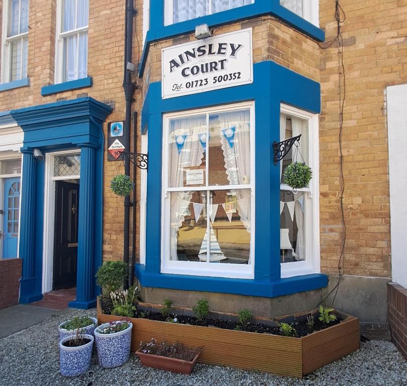una tienda con adornos azules y plantas en la ventana en Ainsley Court Guest House, en Scarborough