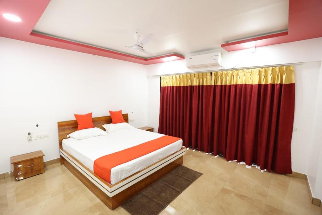 um quarto com uma cama e uma cortina vermelha em Usha Resort em Pālghar