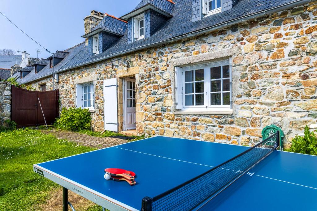 - une table de ping-pong bleue devant une maison en pierre dans l'établissement Morgat, maison familiale, plage à pied, à Crozon
