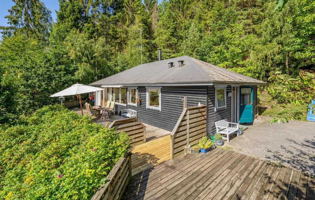a blue house with a deck and an umbrella at 3 Bedroom Stunning Home In Ebeltoft in Ebeltoft