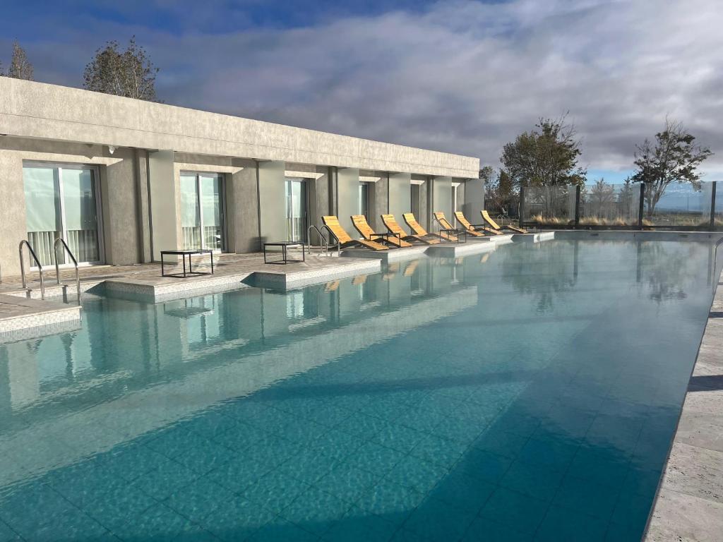 uma grande piscina com espreguiçadeiras em frente a um edifício em TERMAS PISMANTA Hotel & Spa em Las Flores