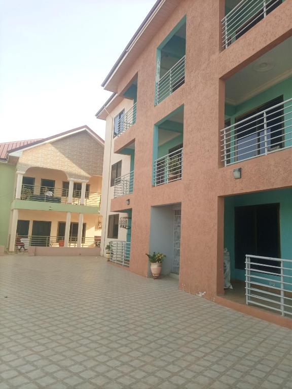 a large brick building with a courtyard in front of it at 2 bedroom apartment in Tema