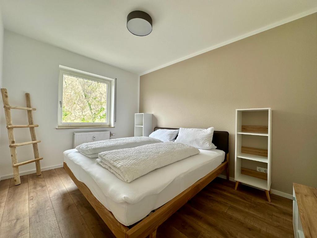 Schlafzimmer mit einem großen weißen Bett und einem Fenster in der Unterkunft Ferienwohnung Rotenfelsblick in Bad Kreuznach