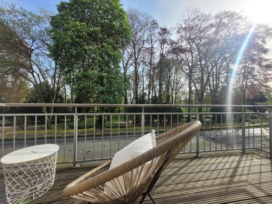 a rattan chair and a table on a deck at Mit Blick in den Emsseepark in Warendorf