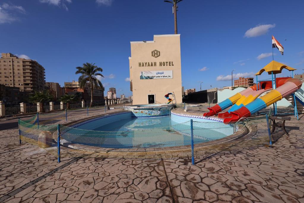 una piscina con toboganes frente a un edificio en فندق حياة دمنهور - Hayat Hotel Damnhour, en Damanhûr