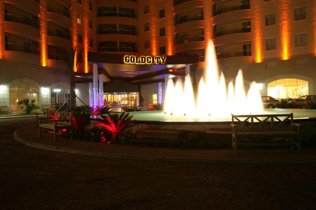 a fountain in front of a building at night at Goldcity Otel Kargıcak in Alanya