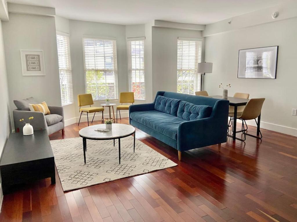 a living room with a blue couch and a table at 440-Luxury Apt Near Light Rail in Hoboken